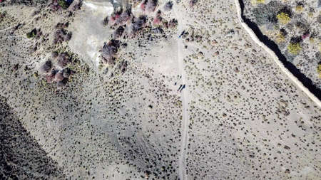 A drone shot of dry Himalayan valley. The valley is located in Mustang region, Annapurna Circuit Trek in Nepal. There is a trekking path in the middle. Barren and steep slopes. Harsh landscape.の写真素材