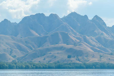 A view on idyllic Komodo Island, Indonesia. Volcanic island is barely overgrown with plants. There...