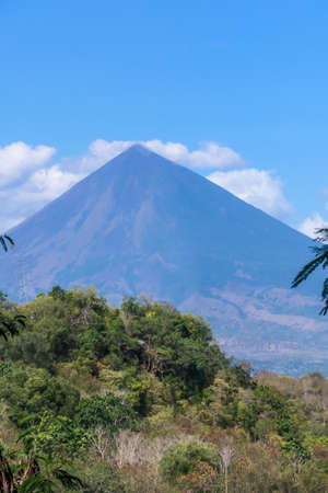 A distant view on Volcano Inierie, Bajawa, Indonesia. The pyramid like mountain towers above the...