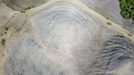 A top down drone shot of a headland formation on Tanjung Aan Beach, Lombok, Indonesia. Few bushes...