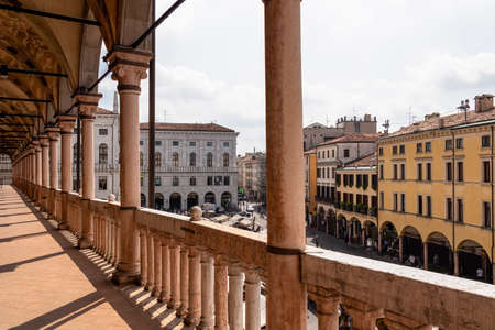 The scenic view on Piazza delle Erbe from the loggia which is the external balcony of Palazzo della Ragione in Padua, Veneto, Italy, Europe. Light beams on beautiful colonnade with column architectureの写真素材