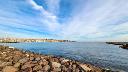 Panoramic view on the waterfront of the city of  Syracuse, Sicily, Italy, Europe EU. Soft light shining on the residential houses at the Mediterranean seaside. Walking along the coastlineの写真素材