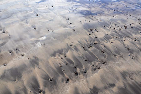Scenic view on the drainage patterns at Costa Adeje beach on Tenerife, Canary Islands, Spain, Europe, EU. Amazing sand artistic sand patterns created from the incoming waves from the Atlantic Oceanの写真素材