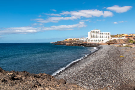 Panoramic view on a pebble stone beach Playa de San Blas near Los Abrigos, Tenerife, Canary Islands, Spain, Europe, EU. Coastline of the Atlantic Ocean. Big white vacation resort Santa Barbaraのeditorial素材