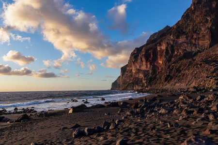 Scenic view during sunset on the volcanic sand beach Playa del Ingles in Valle Gran Rey, La Gomera, Canary Islands, Spain, Europe. Massive cliffs of the La Mercia range. Calm atmosphere at the seasideの写真素材