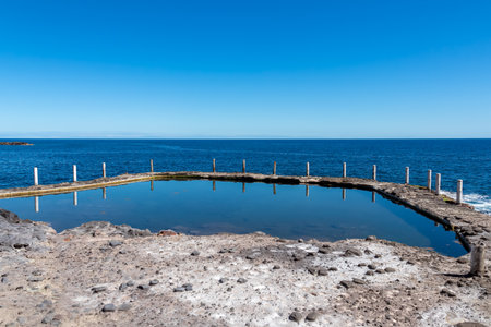 Panoramic view on the Ocean Pool Piscina Natural de Laja de la Sal near the tourist town Puerto de la Cruz, Tenerife, Canary Islands, Spain, Europe. Beautiful reflections on the water surfaceの写真素材