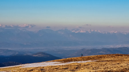 Man hiking on frozen alpine meadow from Ladinger Spitz to Gertrusk, Saualpe, Lavanttal Alps,...