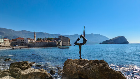 Ballerina statue (dancing girl) with panoramic view of the medieval old town of the coastal city of Budva, Montenegro, Adriatic Mediterranean Sea, Montenegro, Balkan, Europe. Dinaric Alps in the backの写真素材