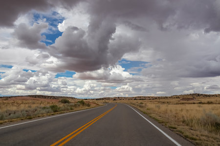 Long empty highway travels through desert of American Southwest near near Moab, Island in the Sky...