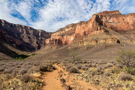 Scenic view on massive mesa cliff The Battleship seen from Bright Angel and Plateau Point hiking trail, South Rim of Grand Canyon National Park, Arizona, USA. Barren terrain in Southwest with blue skyの写真素材