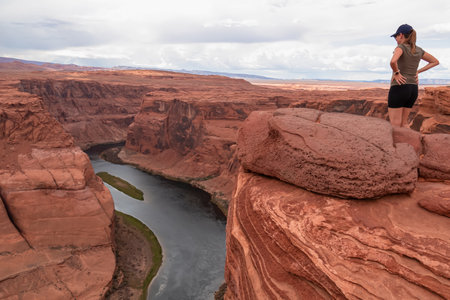 Tourist woman with panoramic aerial view of Horseshoe bend on the Colorado river near Page in summer, Arizona, USA United States of America. Incised meanders in Glen Canyon National Recreation Areaの写真素材