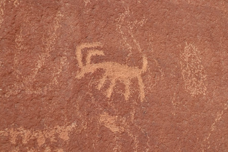 Close up view of Native American rock art (Petroglyphs) on red Aztek sandstone wall in Petroglyph Canyon along Mouse Tank hiking trail in Valley of Fire State Park in Mojave desert, Nevada, USAの写真素材