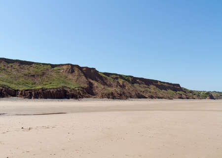 coastline with sand and a clear blue skyの写真素材