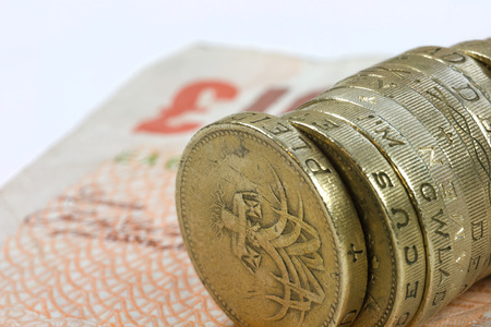 One pound coins on the edge on a white backgroundの写真素材