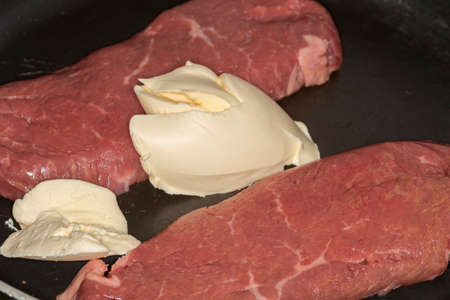 Beef steak fried in pan with butterの写真素材