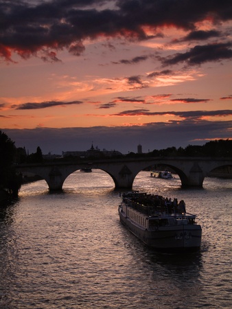 Late spring sunset on the Seine in Paris with a boat about to pass the Pont Royal bridge  Focus on boat の写真素材