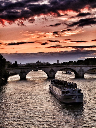 Late spring sunset on the Seine in Paris with a boat about to pass the Pont Royal bridge. Focus on boat.の写真素材