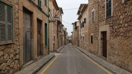 empty narrow street in Soller Mallorca with typical historic houses on both sidesの写真素材