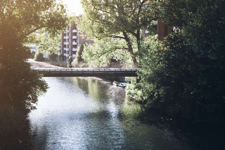 pedestrian bridge across a channel in residential neighborhood in Hamburg, Germany in warm evening sunlightの写真素材