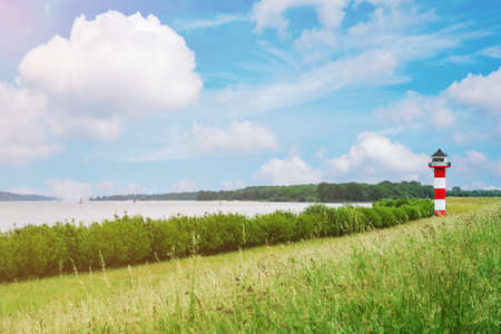 typical red and white lighthouse under beautiful summer skyの写真素材