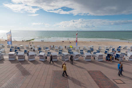 Westerland, Germany 09.03.2017 people and baltic beach chairs on boardwalk and beach of Westerland, Syltのeditorial素材