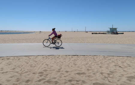 Santa Monica, California, USA 03.31.2017 bikepath on beach with female cyclist and typical lifeguard tower in backgroundのeditorial素材
