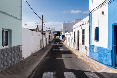 narrow alley in fishermens town on Fuerteventura Island under blue sky
