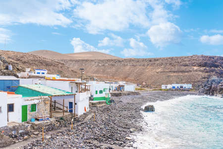 houses of small fishermens village against cliffs and ocean at Fuerteventura islandの写真素材