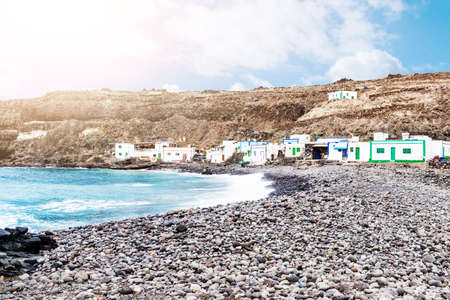 houses of small fishermens village Los Molinos against cliffs and ocean at Fuerteventura islandの写真素材