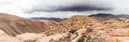 panoramic shot of volcanic mountainous landscape on island of Fuerteventura, Spain und overcast skyの写真素材
