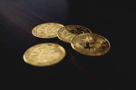 close-up of golden bitcoin coins on wooden table surfaceの写真素材