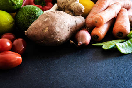 closeup shot of fresh raw organic fruits and vegetables on slate kitchen counter healthy eating conceptの写真素材