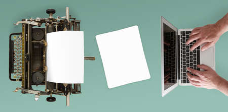 top view of vintage manual typewriter and man typing on notebook computer on deskの写真素材