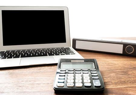 low angle view of calculator, laptop and file folder on wooden desk business and finance concept