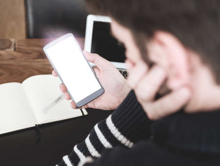 high angle view close-up of man using smart phone at office desk templateの写真素材