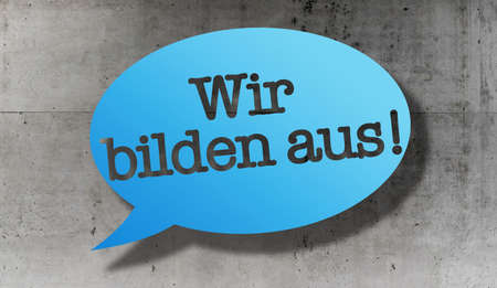 text WIR BILDEN AUS, German for we train apprentices, in speech bubble against concrete wallの写真素材