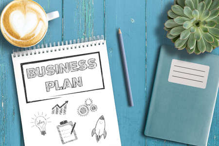 business strategy concept, top view of business plan on notepad on rustic wooden table