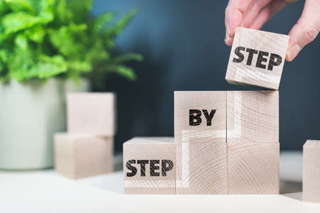 words step by step on wooden blocks, growth and progress conceptの写真素材