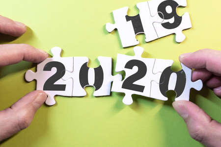 new year concept with top view of hands replacing puzzle pieces with 2019 to 2020
