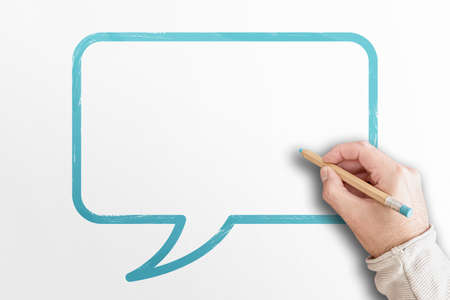 hand holding pencil writing in speech bubble on white background with copy spaceの写真素材