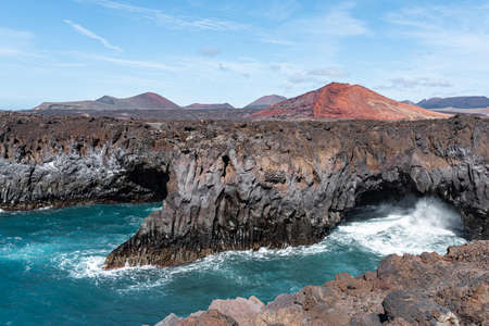 bluff coast and vulcanic landscape at Los Hervideros, Lanzarote, against blue sky