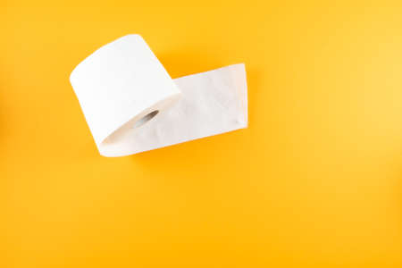 directly above shot of single roll of toilet paper on orange backgroundの写真素材