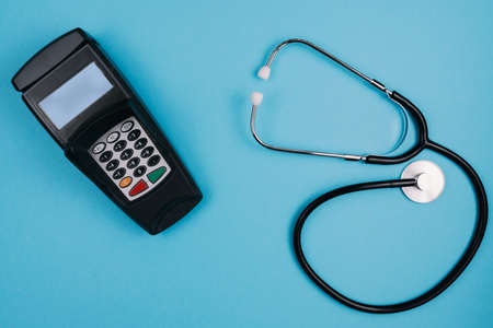cost and payment for medical treatment or copay concept, above shot of stethoscope and credit card...