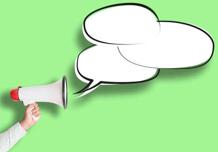 hand holding megaphone and speech bubble against green background, message template with copy space