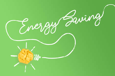 yellow paper ball light bulb with cable forming text ENERGY SAVING, sustainability conceptの写真素材