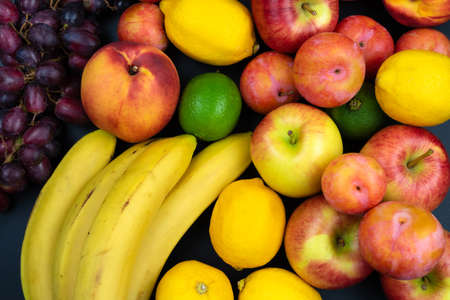 above view of fresh organic fruits on black tableの写真素材