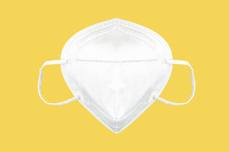 front view of FFP2 face mask, respirator isolated on yellow background, protective face mask to lower risk of covid-19 coronavirus transmissionの写真素材