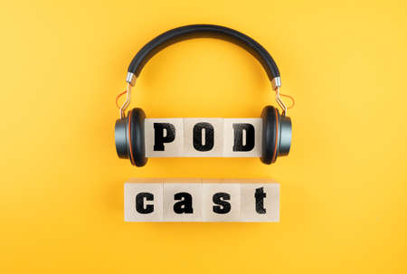 word PODCAST on wooden blocks and headphones on orange background, podcasting conceptの写真素材