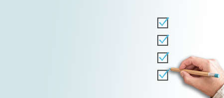 person ticking checkboxes with blue pen on checklist or to-do-list with copy spaceの写真素材
