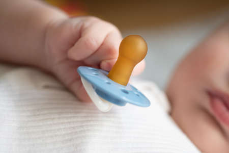 close-up view of hand of baby holding pacifier